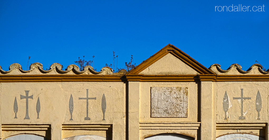 Decoració de creus entre dos xiprers al cementiri de Maià de Montcal a la Garrotxa.