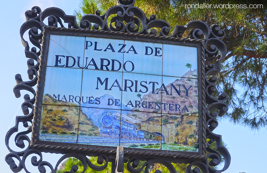 Indicador de la plaça Eduard Maristany de Sitges, amb el dibuix d'un tren.