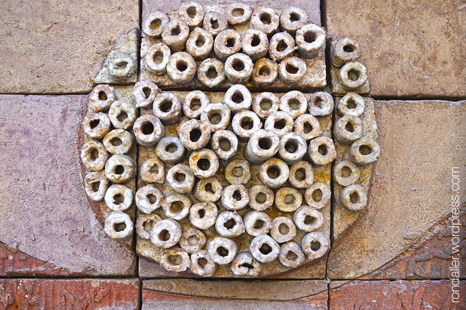 El mural del Col·legi de Metges obra de Joan Vila Grau i Jordi Aguadé. Cercle en relleu.