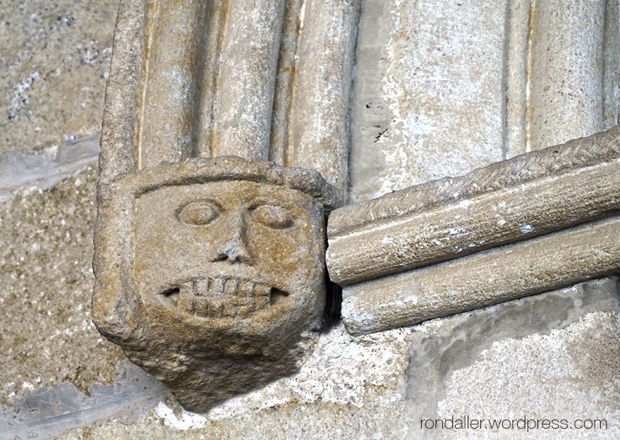 Cap ensenyant les dent a la portalada de l'església de Santa Agnès de Malanyanes.