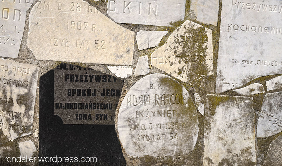 Trossos de lloses funeràries en un mur.