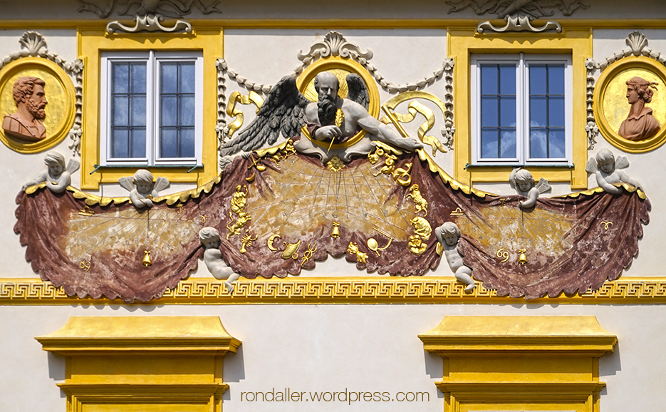 Gran rellotge de sol al Palau Wilanów on un personatge amb ales esten una gran peça de roba.