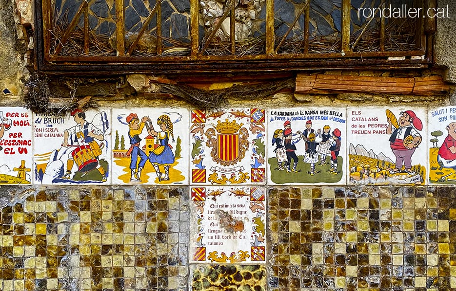 Decoració amb rajoles amb frases i motius populars catalans al carrer Isaac Albéniz.