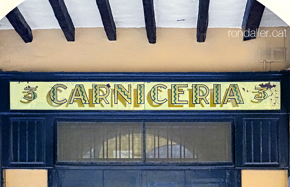 Rètol de vidre pintat en una carnisseria del carrer Prat de la Riba de Castelló d’Empúries.