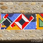 Mosaic de tesel·les amb les eines de paleta a la llinda d’un edifici de L’Esquirol a Osona.