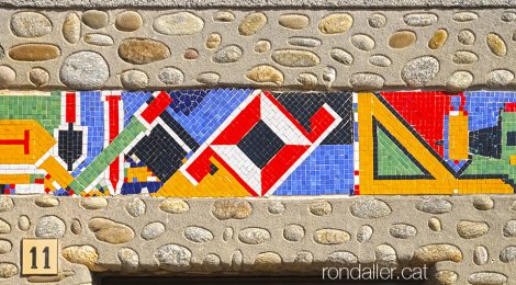 Mosaic de tesel·les amb les eines de paleta a la llinda d’un edifici de L’Esquirol a Osona.