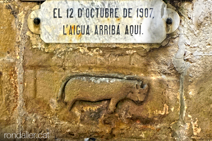 Relleu d'un toro i inscripció a la Font de la Vila amb la data de l'aiguat del 1907. Segarra, Vall del Llobregós.