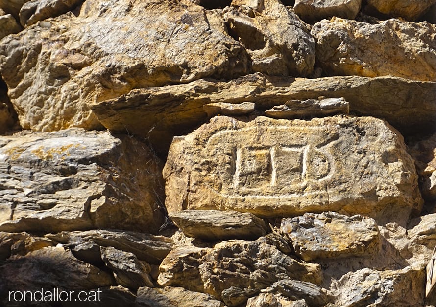 Pedra gravada amb l'any 1775 encastada en una paret. Urgellet. Alt Urgell.