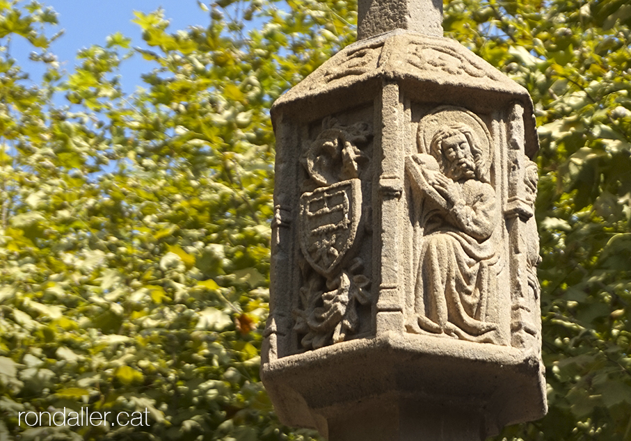 Detall dels relleus del tambor de la creu de terme de Tremp, obra gòtica del segle XVII, amb un escut i una figura.