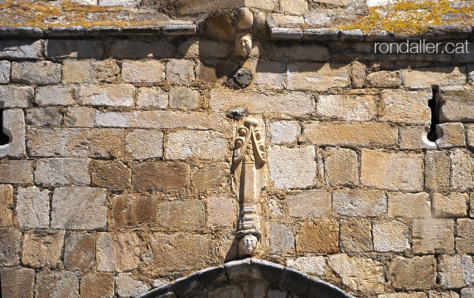 Església de Sant Martí de Gausac a la Vall d'Aran. Detall dels caps en relleu a l'exterior del nàrtex o atri.