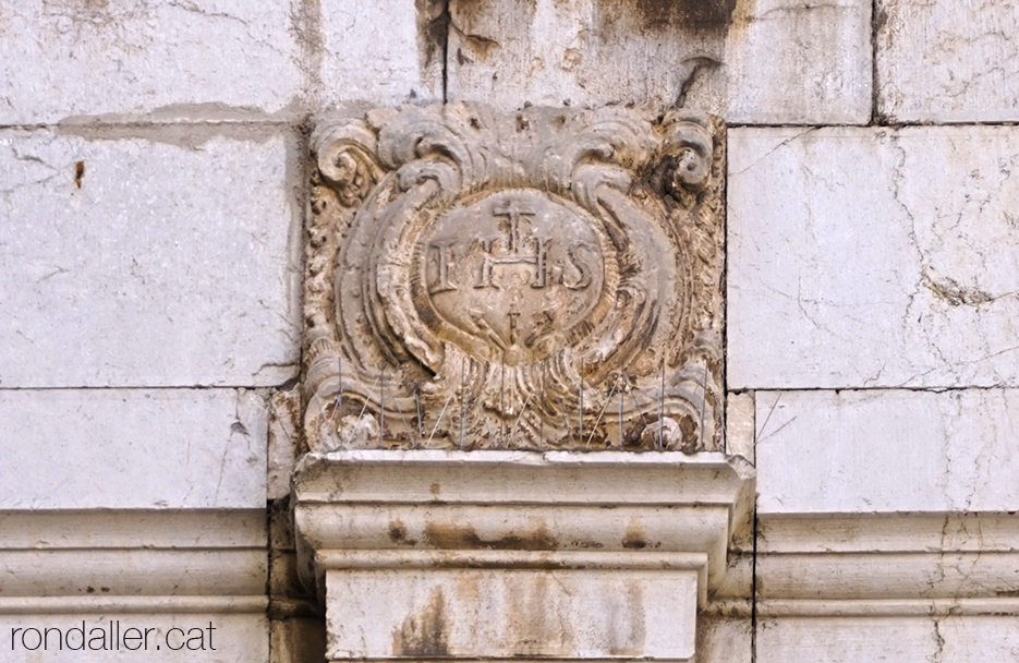 El monograma IHS a la porta lateral de l'església de Sant Antoni Abat de Vilanova i la Geltrú.