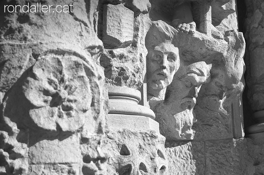 Detall dels caps esculpits a l'entrada de la cripta del Sagrat Cor.