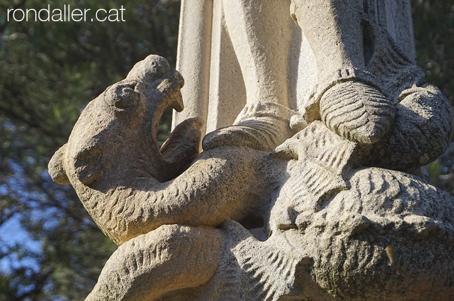 Detall escultòric de la creu de terme, amb el drac.