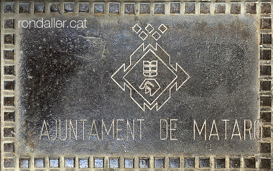 Versió sintetitzada de l'escut de Mataró en una tapa de clavegueram.