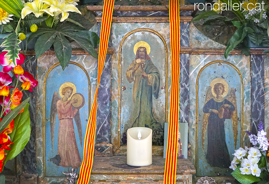 Altar pintat amb la imatge de Crist entre dos àngels tocant instruments.
