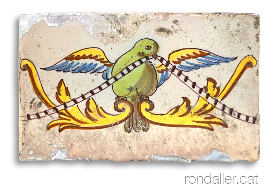 Taulell barroc amb un ocell sostenint una cinta.