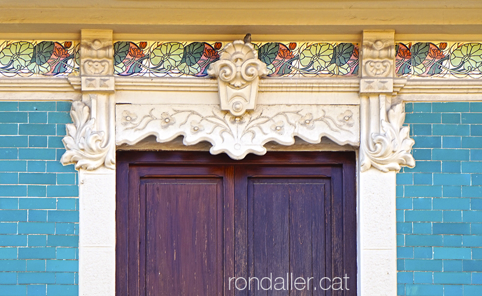 Sanefa de rajoles modernistes sota el ràfec d'una casa.