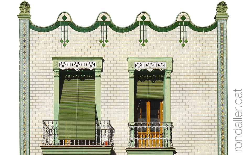 Façana modernista decorada amb rajoles blanques i verdes.