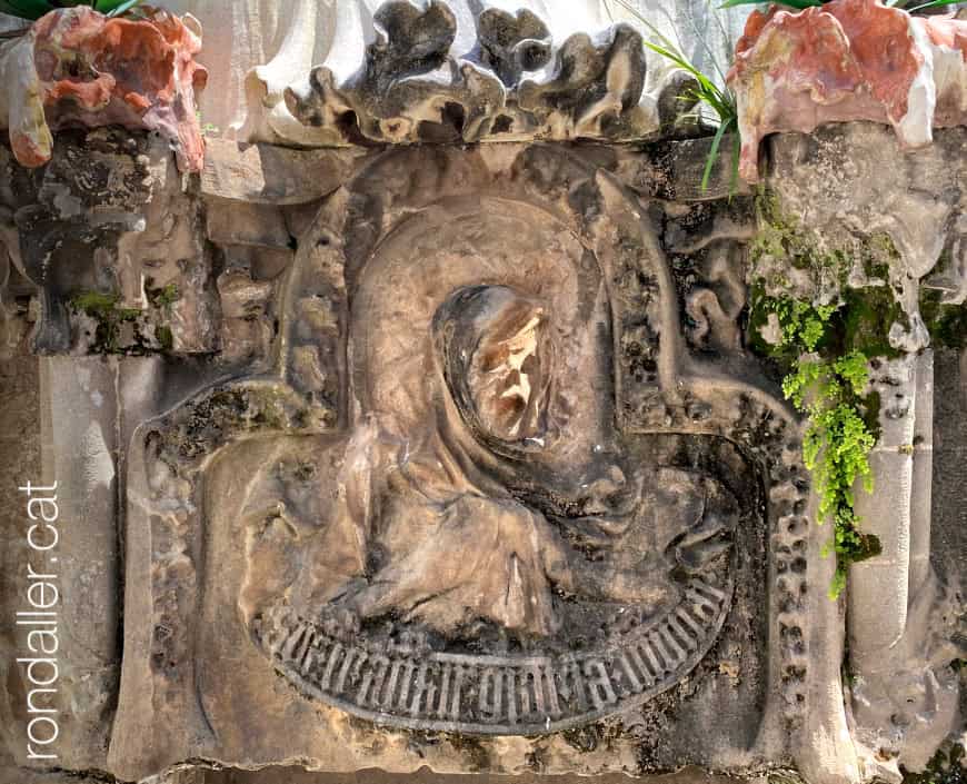 Detall escultòric amb el relleu d'una calavera amb una inscripció.