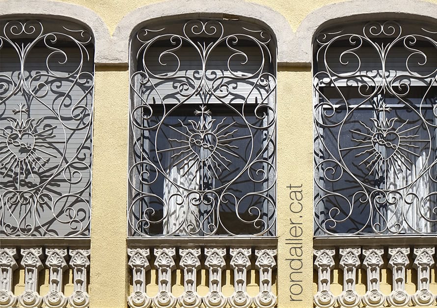 Imatge del Sagrat Cor a les reixes de ferro d'un edifici de Banyoles.