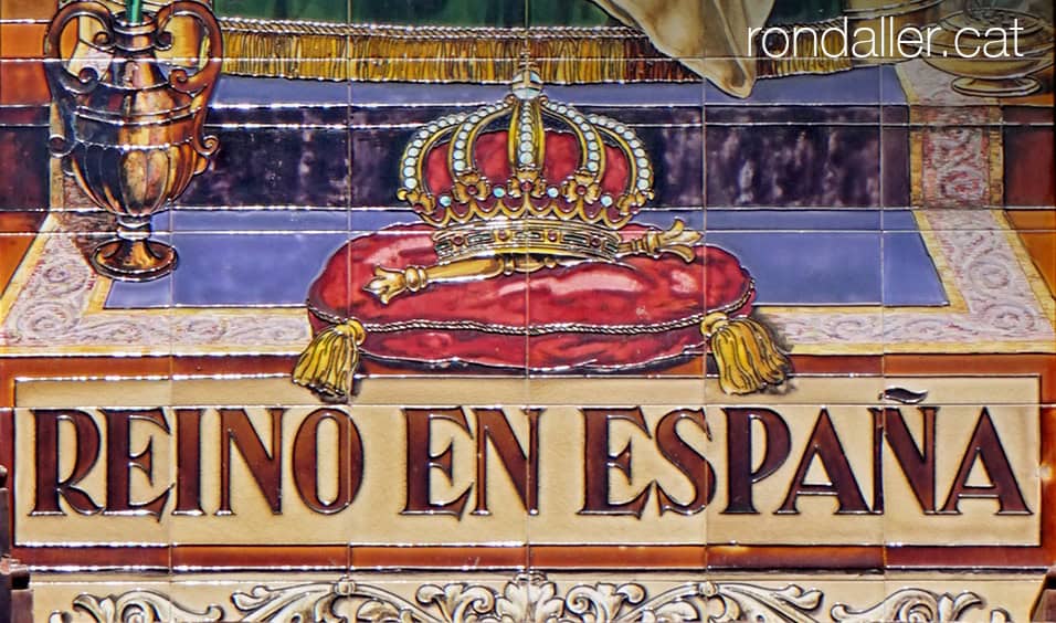 Detall d'un mosaic de rajoles a Terrassa amb la imatge d'una corona i d'un ceptre.