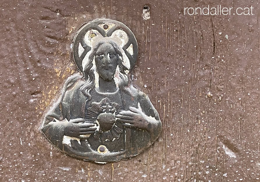 Placa de llautó amb la imatge del Sagrat Cor a Sant Martí Sesgueioles.