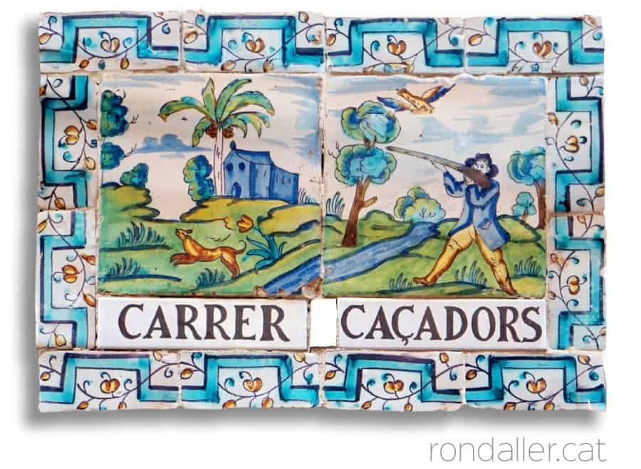 Conjunt de rajoles amb el nom del carrer Caçadors i una escena de cacera.