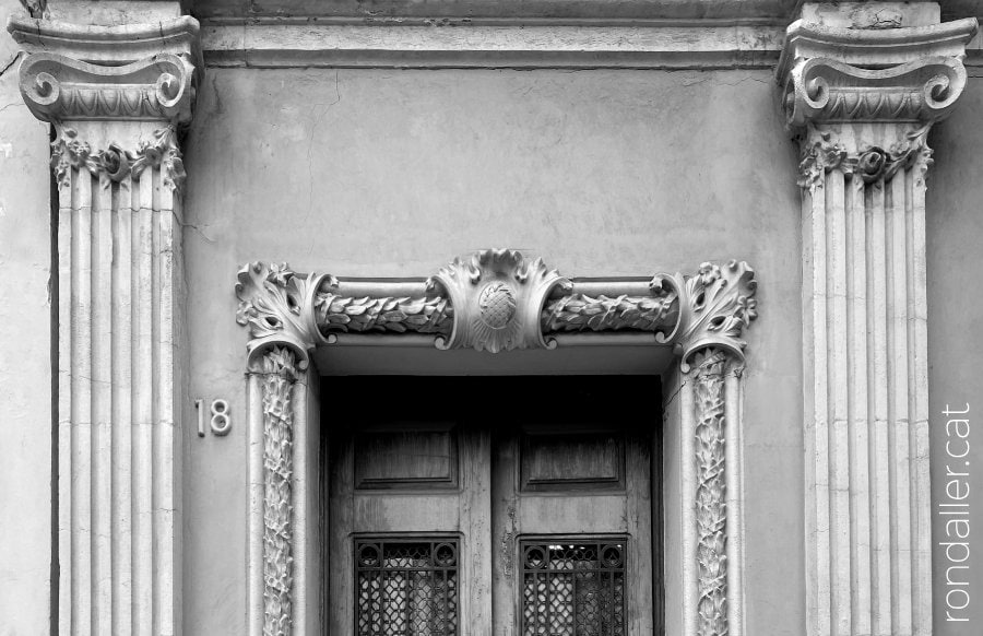 Motllura i pilastres que decoren una de les entrades de l'edifici.