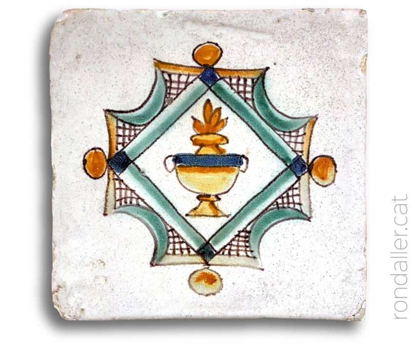 Rajola de mostra del Museu Can Tinturé amb la imatge d'una llàntia o llumenera.