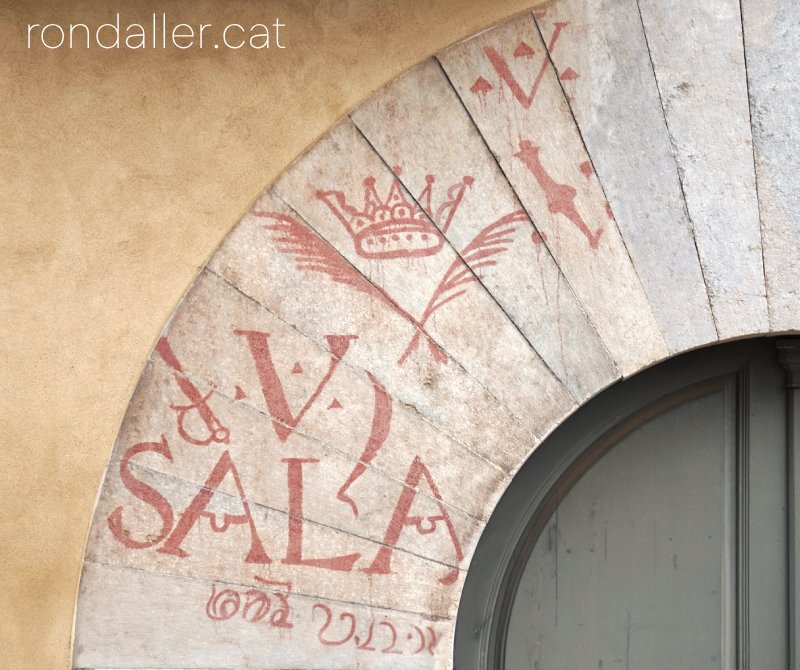 Portal de la casa de l'Ardiaca de Girona amb un víctor pintat.