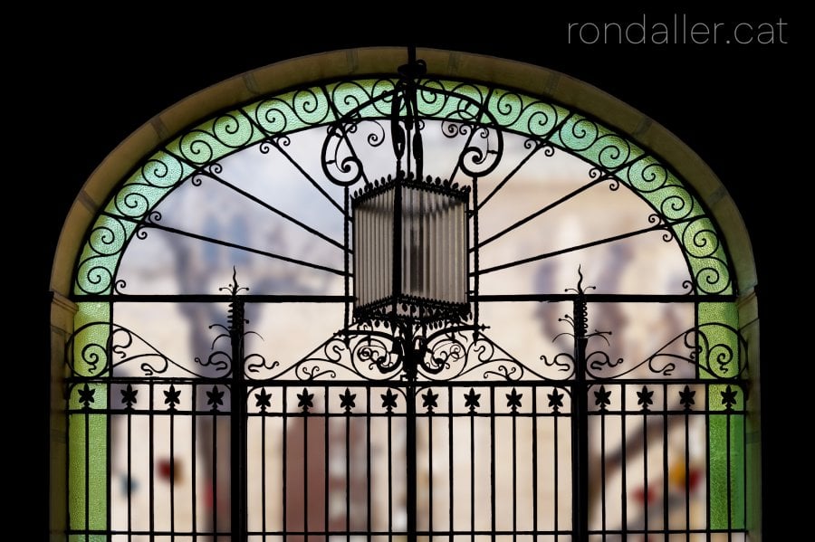 Vitrall i reixa de la portalada d'accés al pati central del recinte hospitalari.