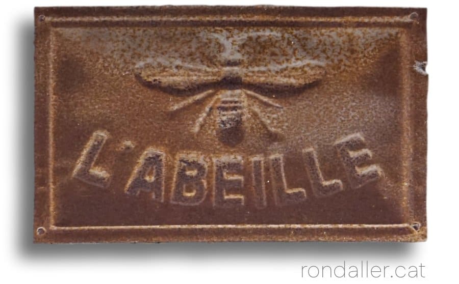 Placa metàl·lica en relleu d'assegurances L'Abeille a Montblanc.