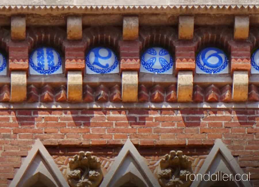 Les inicials de Pau Gil i Serra en un fris ceràmic sota el ràfec de la teulada.