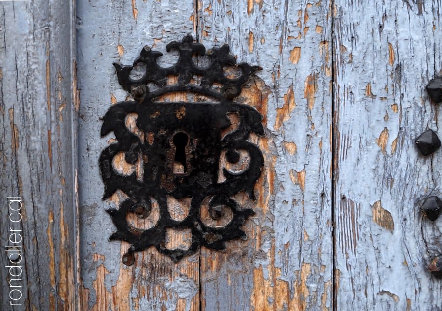 Pany de la porta de l'església Nova, amb una corona al damunt.