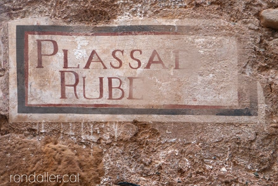 Antiga placa de carrer pintada amb el nom de la plaça de Rubert.